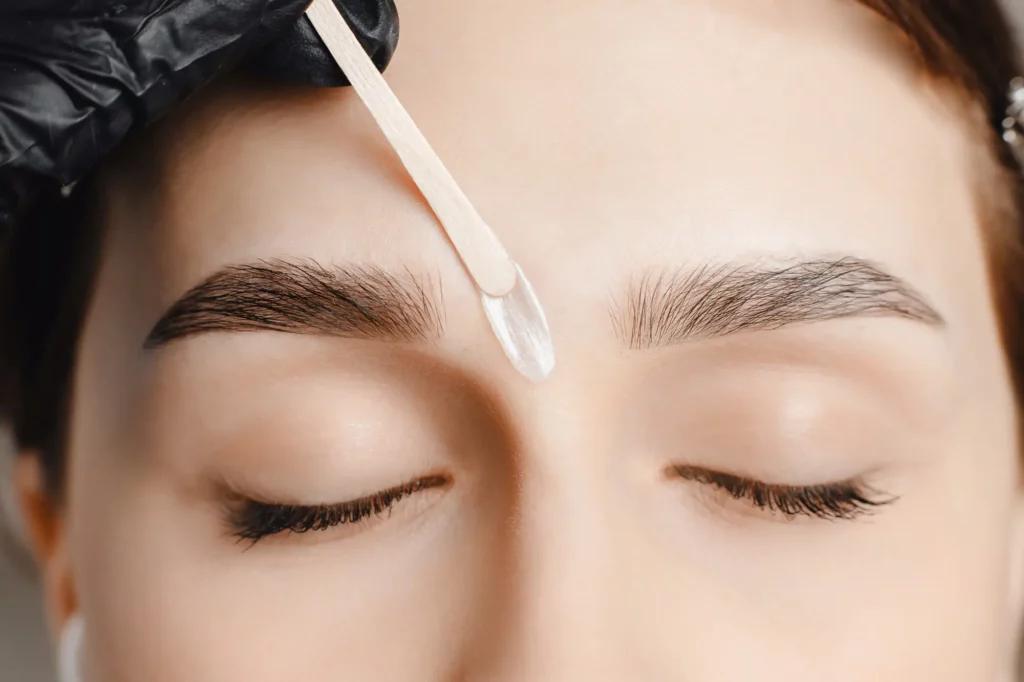 Facial Waxing: Benefits, Process, and What to Expect for Smooth Skin a person getting a wax on their eyebrows