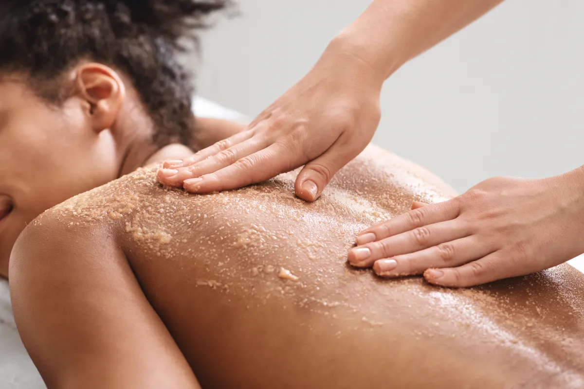 a person receiving a scrub on a woman's back