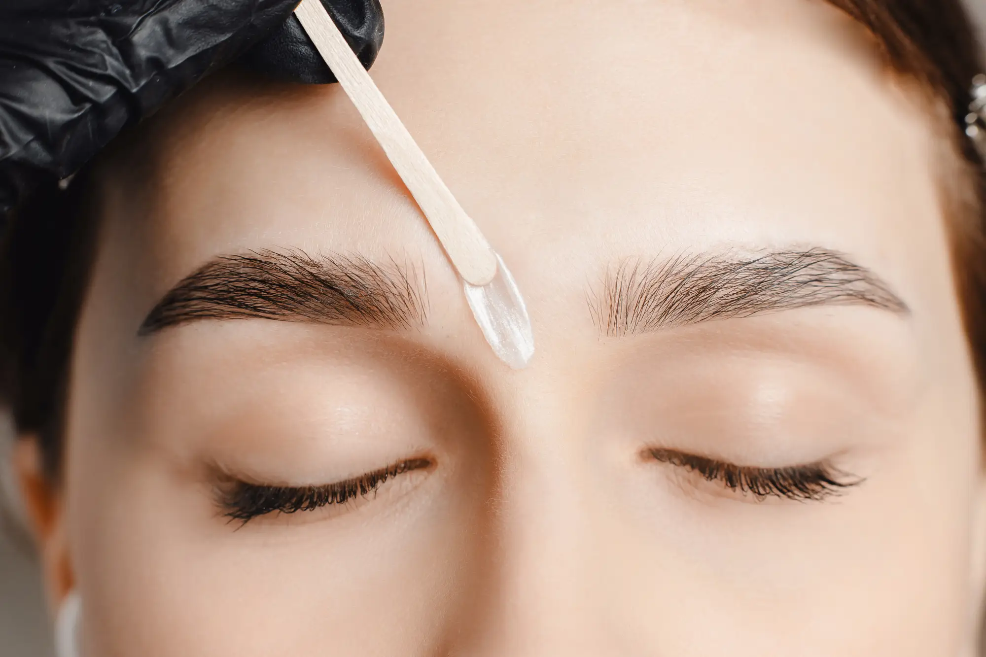 a person getting a wax on their eyebrows