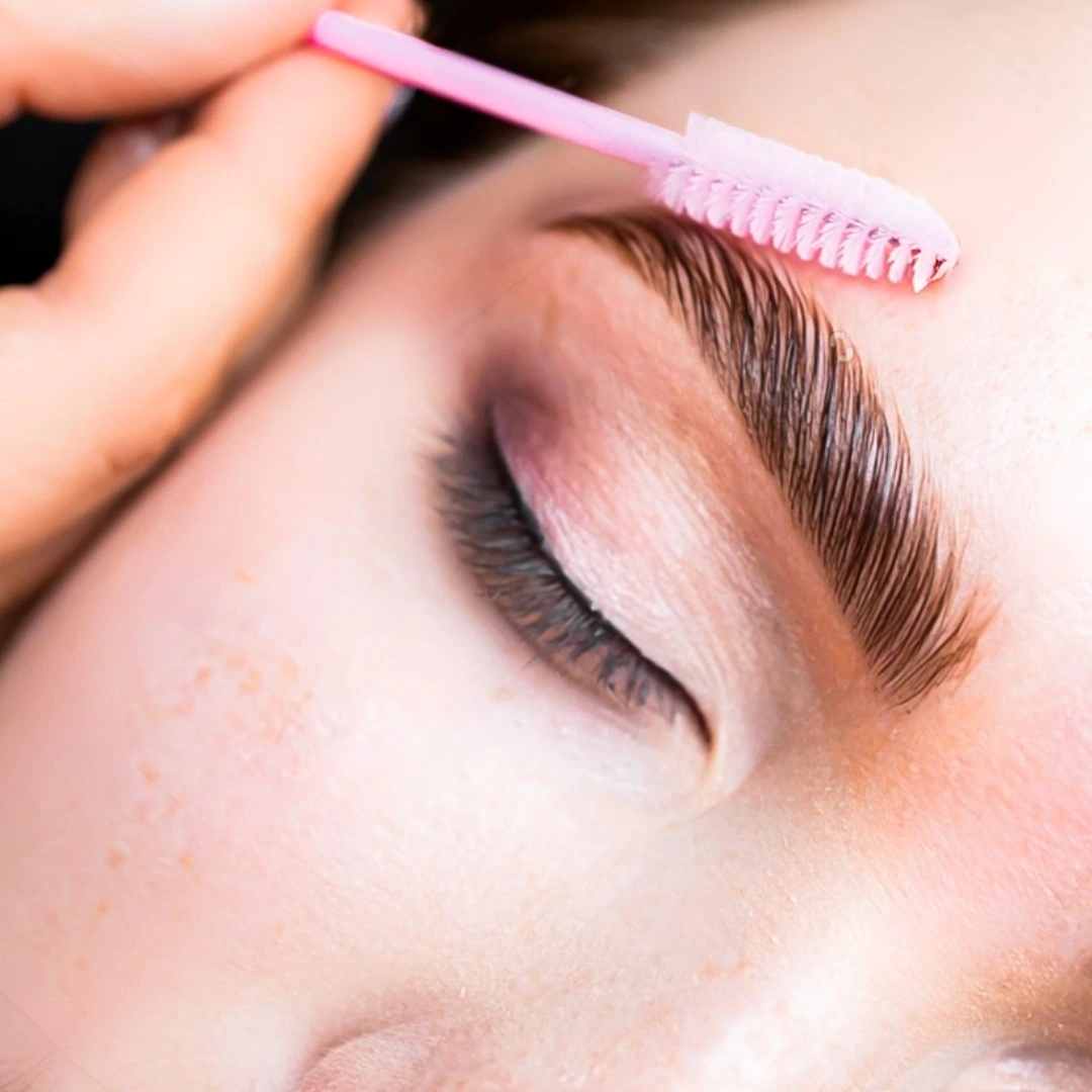 a person with a pink brush on their eyebrow