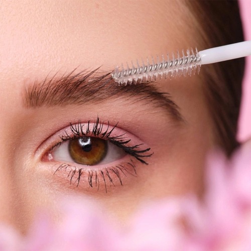 a woman applying makeup on her eyebrows