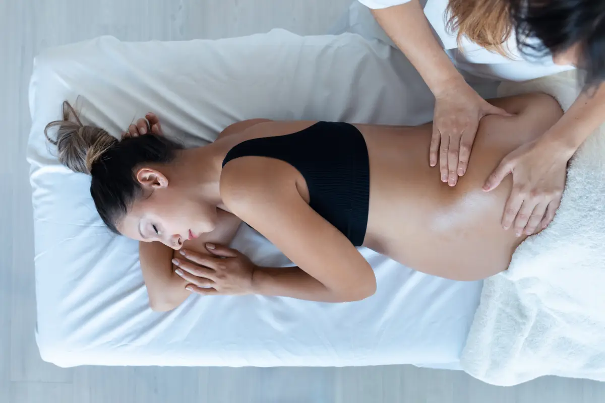 a woman lying on a bed with her hands on her stomach
